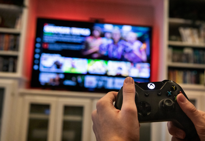Eine weibliche Hand bedient die Konsole einer Xbox.